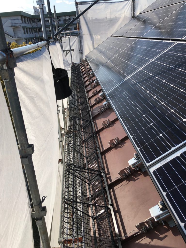 スノーメルト 太陽光ソーラーパネル落雪防止フエンス 結束線結び作業中 屋根6寸勾配西側方向